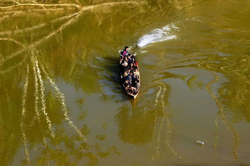 Ashaninka Indigenous maneuver in a boat on the Amonia River, in the Apiwtxa village, Acre State, Brazil, Sunday, June 23, 2024. (AP Photo/Jorge Saenz)