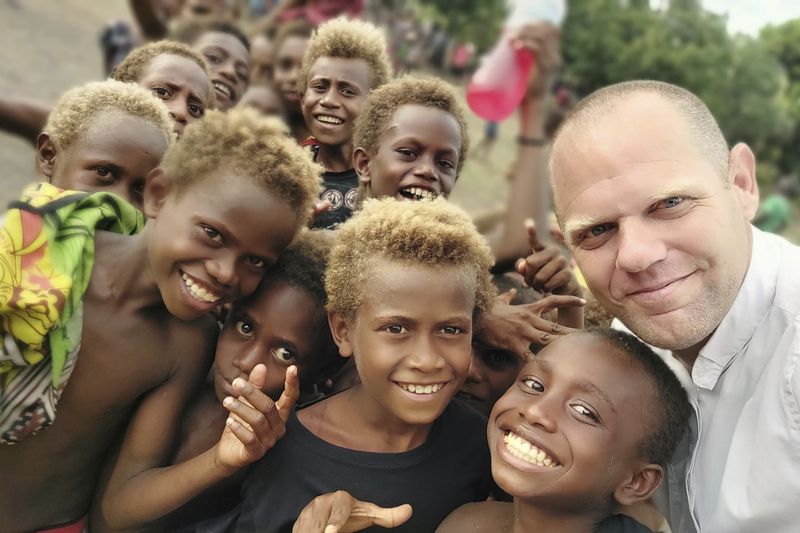 This undated photo provided by Fr Tomas Ravaioli shows young villagers posing for a photo with him in Rabaul, Papua New Guinea. (Fr Tomas Ravaioli via AP)