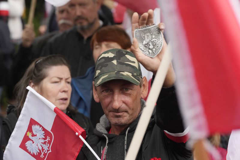 Backers of the right-wing opposition party Law and Justice take part in a protest ally of a few thousand people against the policies of Prime Minister Donald Tusk's Cabinet in Warsaw, Poland, Saturday Sept. 14, 2024. (AP Photo/Czarek Sokolowski)