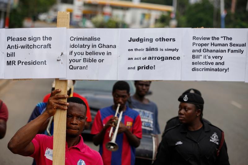 Texas Kadri Moro, the Executive Director of Arise for Justice International, protests with placards nailed on a cross on the street of Accra, Ghana, Thursday Sept 12, 2024. Texas Kadiri Moro is an unusual figure amid the LGBTQ+ rights activists in the coastal West African nation of Ghana. He is heterosexual, married to a woman and a father of six. He is a teacher. And he is a practising Muslim. (AP Photo/Misper Apawu)