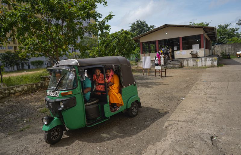 A Sri Lankan family sit in a rickshaw as they leave a polling station after casting their votes in Colombo, Sri Lanka, Saturday, Sept. 21, 2024. (AP Photo/Eranga Jayawardena)