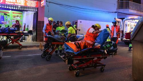 Medics take injured people away from a building that collapsed in Palma de Mallorca, Spain, Thursday May 23, 2024. Spanish emergency authorities say that four people have died and 21 more have been injured when a building collapsed on the island of Mallorca. (Isaac Buj/Europa Press via AP)