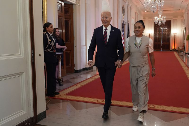 President Joe Biden walks with Dawn Staley, Coach of the University of South Carolina Women's basketball team, for an event in the East Room of the White House in Washington, Tuesday, Sept. 10, 2024, to welcome the University of South Carolina Gamecocks Women's basketball team and celebrate their 2023-2024 NCAA championship season. (AP Photo/Susan Walsh)