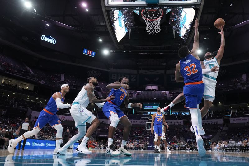 Charlotte Hornets forward Miles Bridges shoots over New York Knicks center Karl-Anthony Towns during the first half of a preseason NBA basketball game on Sunday, Oct. 6, 2024, in Charlotte, N.C. (AP Photo/Chris Carlson)