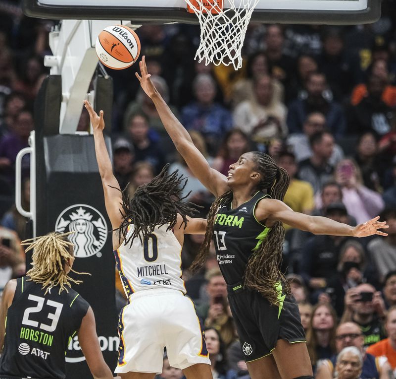Indiana Fever's Kelsey Mitchell (0) shoots just past the hand of Seattle Storm's Ezi Magbegor during the first half of a WNBA basketball game Thursday, June 27, 2024, in Seattle. (Dean Rutz/The Seattle Times via AP)