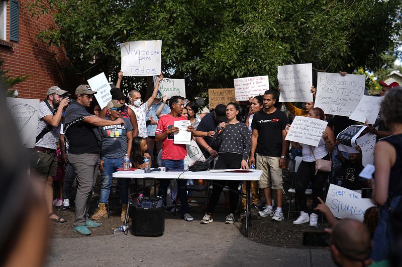 Resident Jaun Carlos Jimenez, center left, listens as Jeraldine Mazo, center right, speaks during a rally staged by the East Colfax Community Collective to address chronic problems in the apartment buildings occupied by people displaced from their home countries in central and South America Tuesday, Sept. 3, 2024, in Aurora, Colo. (AP Photo/David Zalubowski)