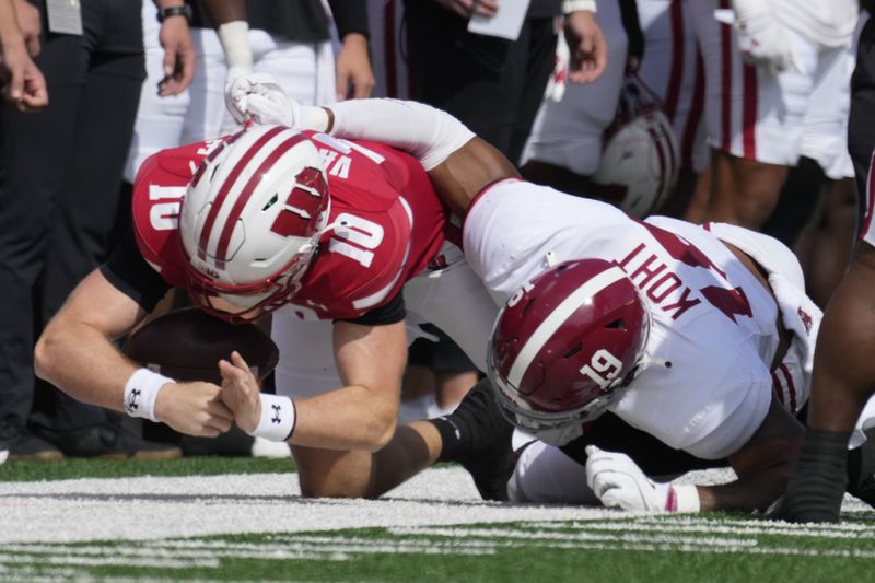 Alabama's Keanu Koht (19) stops Wisconsin's Tyler Van Dyke (10) during the first half of an NCAA college football game Saturday, Sept. 14, 2024, in Madison, Wis. Van Dyke was injured on the play. (AP Photo/Morry Gash)