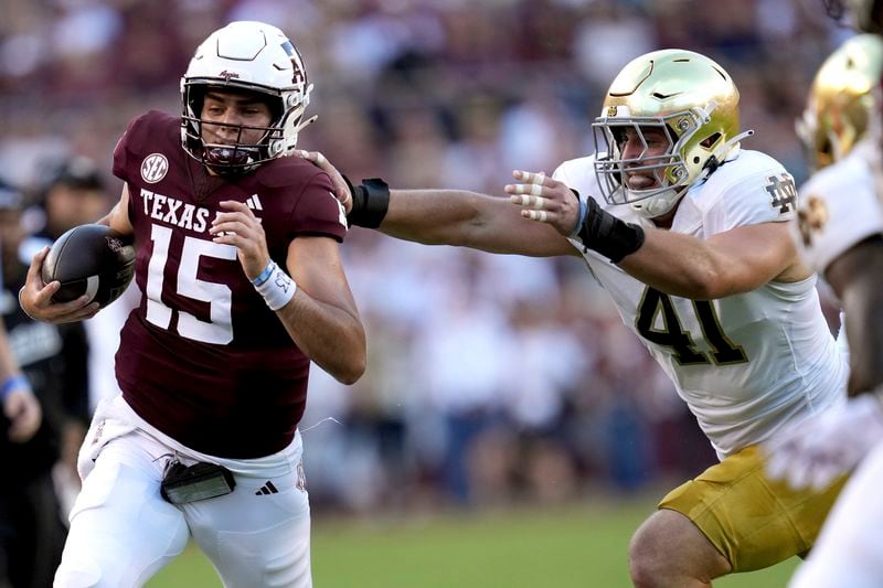 Texas A&M quarterback Conner Weigman (15) is chased out of bounds after a scramble by Notre Dame defensive lineman Donovan Hinish (41) during the first half of an NCAA college football game, Saturday, Aug. 31, 2024, in College Station, Texas. (AP Photo/Sam Craft)