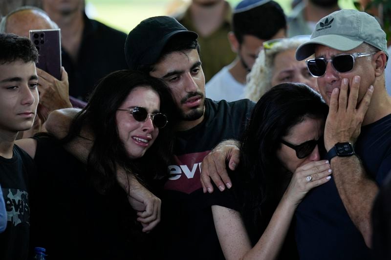 Relatives and friends mourn during the funeral of slain hostage Almog Sarusi, who was killed in Hamas captivity in the Gaza Strip, at a cemetery in Ra'anana, Israel, Sunday, Sept. 1, 2024. (AP Photo/Ariel Schalit)