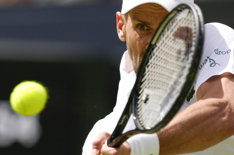 Serbia's Novak Djokovic plays a backhand return to Britain's Jacob Fearnley during their second round match at the Wimbledon tennis championships in London, Thursday, July 4, 2024. (AP Photo/Kirsty Wigglesworth)