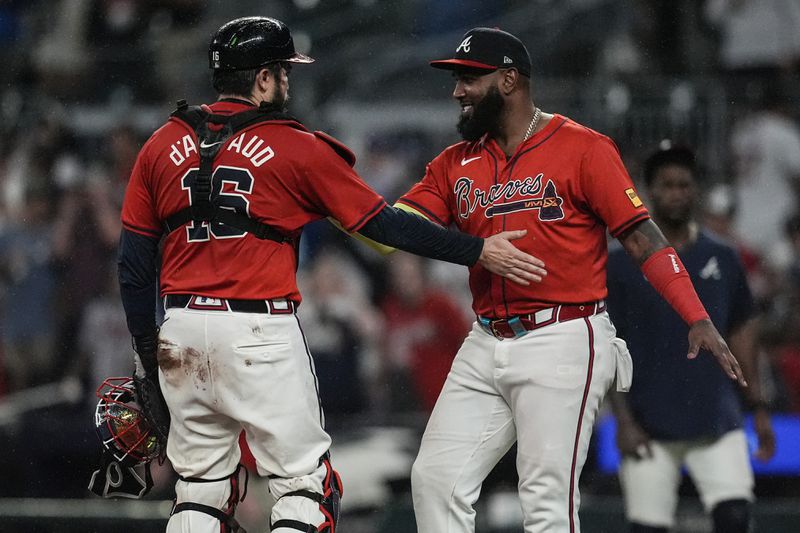 Atlanta Braves designated hitter Marcell Ozuna, right, celebrates a win with catcher Travis d'Arnaud after a baseball game against the Los Angeles Dodgers, Friday, Sept. 13, 2024, in Atlanta. (AP Photo/Mike Stewart)