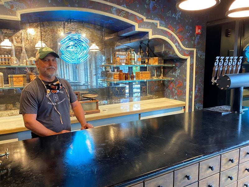 Brian Purcell stands behind the bar inside Three Taverns Imaginarium. Bob Townsend for The Atlanta Journal-Constitution 
