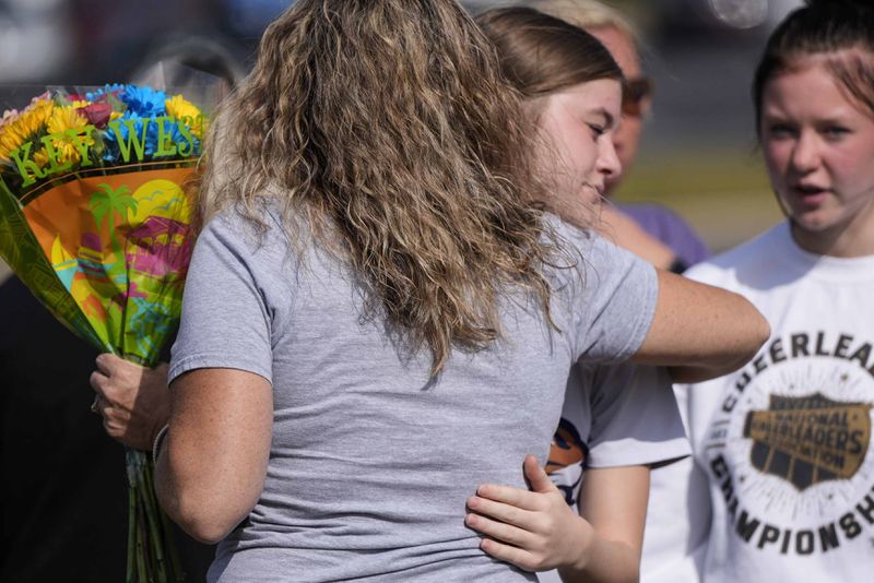 People embrace at a makeshift memorial after a shooting Wednesday at Apalachee High School, Thursday, Sept. 5, 2024, in Winder, Ga. (AP Photo/Mike Stewart)