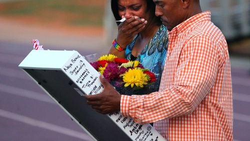 Alexis and John Poole, the parents of 16-year-old Jasmine Poole, are presented a tribute from cheerleaders to remember their daughter in the football stadium at Dutchtown High School on Thursday, May 8, 2014, in Hampton. Jasmine Poole had been cheering since she was five-years-old and was a cheerleader at the school. CURTIS COMPTON / CCOMPTON@AJC.COM