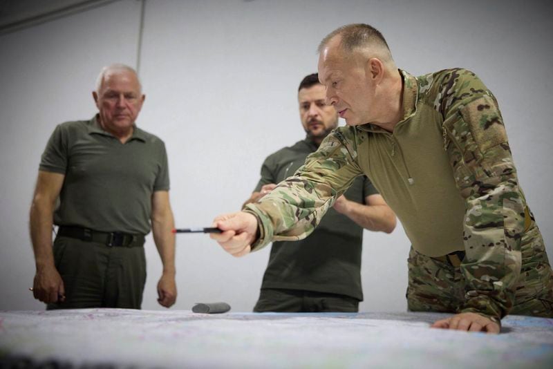 In this photo provided by the Ukrainian Presidential Press Office, Ukrainian President Volodymyr Zelenskyy, center, Commander-in-Chief Oleksandr Syrsky, right, look at a map during their visit to Sumy, Ukraine, Thursday, Aug. 22, 2024. (Ukrainian Presidential Press Office via AP)