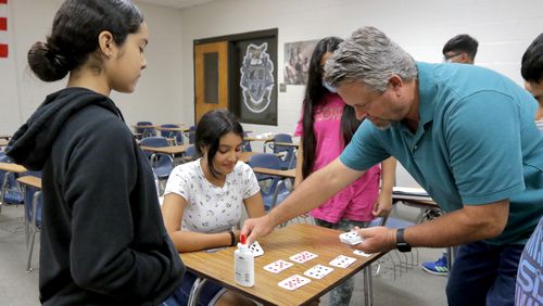Teacher Jack Gann helps his students set up a math magic trick to demonstrate during Gwinnett County's Hispanic Mentoring Program summer camp at Meadowcreek High School on Wednesday, July 14, 2021. (Christine Tannous / christine.tannous@ajc.com)