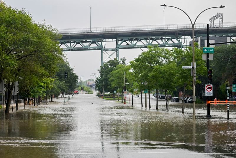 A flooded street is shown following a water main break in Montreal, Friday, Aug. 16, 2024, causing flooding in several streets of the area. (Graham Hughes/The Canadian Press via AP)