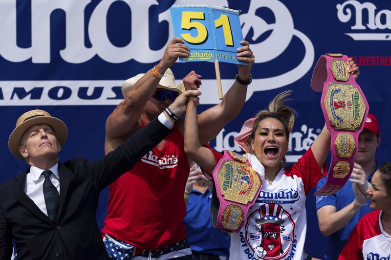 Miki Sudo, right, reacts after winning the women's division in the Nathan's Famous Fourth of July hot dog eating contest, Thursday, July 4, 2024, at Coney Island in the Brooklyn borough of New York. Sudo ate a record 51 hot dogs. (AP Photo/Julia Nikhinson)