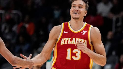 Atlanta Hawks guard Bogdan Bogdanovic (13) celebrates his three-point shot against the Charlotte Hornets during the first half of an NBA basketball game, Wednesday, April 10, 2024, in Atlanta. (AP Photo/Mike Stewart)