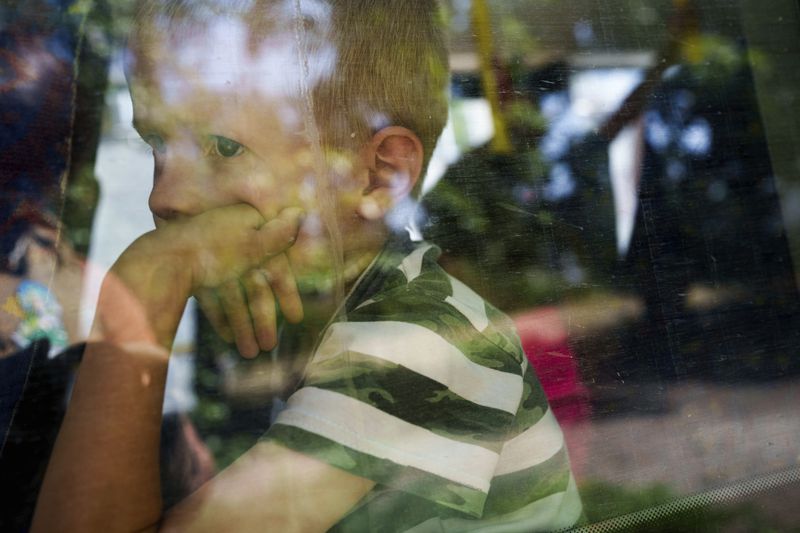 A boy sits in a bus during evacuation in Pokrovsk, Donetsk region, Ukraine, Monday, August 19, 2024. Due to the advance of Russian troops, the war affects more and more new settlements to the west of the Donetsk region. Intensive shelling forced people to leave homes. (AP Photo/Evgeniy Maloletka)