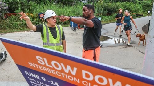 Meghan Injaychock (left), senior project manager for the Atlanta Beltline, helps direct runner Marvin Brooks at 10th Street and Monroe Drive on Monday morning.