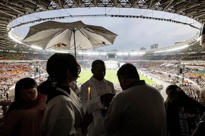 A priest gives Holy Communion to the faithful during a holy mass led by Pope Francis at the Gelora Bung Karno Stadium, in Jakarta, Thursday, Sept. 5, 2024. (Yasuyoshi Chiba/Pool Photo via AP)