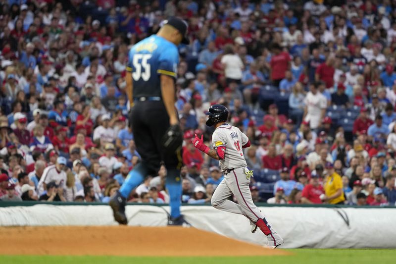 Atlanta Braves' Orlando Arcia, right, reacts after hitting a home run against Philadelphia Phillies pitcher Ranger Suárez during the third inning of a baseball game, Friday, Aug. 30, 2024, in Philadelphia. (AP Photo/Matt Slocum)