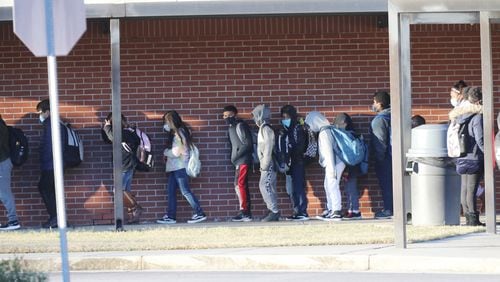 Students arrive at Norcross Elementary School on Jan. 10, 2022. Across Georgia, schools are determined to keep their doors open amid high coronavirus rates that have led to staffing shortages. (Miguel Martinez for The Atlanta Journal-Constitution)