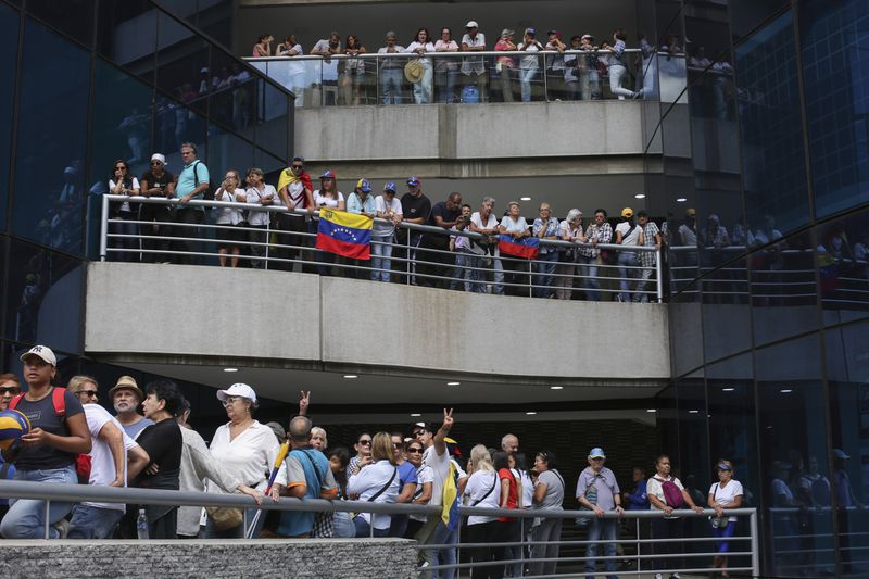 Opposition supporters protest the reelection of President Nicolás Maduro one month after the disputed vote, which opposition leaders claim they won by a landslide, at a shopping mall in Caracas, Venezuela, Wednesday, Aug. 28, 2024. (AP Photo/Cristian Hernandez)