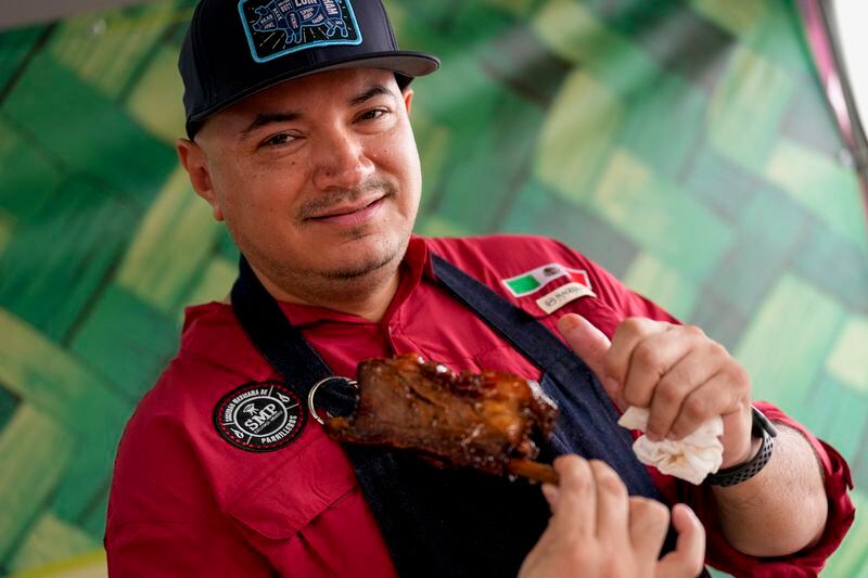 Fernando Martinez of Sociedad Mexicano de Parrillieros team holds a rib at the World Championship Barbecue Cooking Contest, Friday, May 17, 2024, in Memphis, Tenn. (AP Photo/George Walker IV)