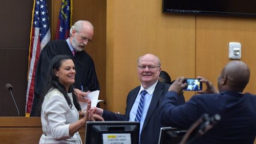 August 14, 2018 Atlanta - Meria Carstarphen, superintendent of Atlanta Public Schools (left), and attorney Charles Huddleston pose in front of Judge Alan Harvey (background) after ruling to allow Fulton County to collect tax money on Tuesday, August 14, 2018. HYOSUB SHIN / HSHIN@AJC.COM