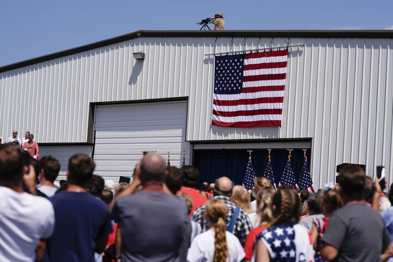 Rooftop security is in position prior to Republican presidential nominee former President Donald Trump speaks at a rally, Wednesday, Aug. 21, 2024, in Asheboro, N.C. Wednesday's event is the first outdoor rally Trump has held since the attempted assassination of the former president. (AP Photo/Julia Nikhinson)