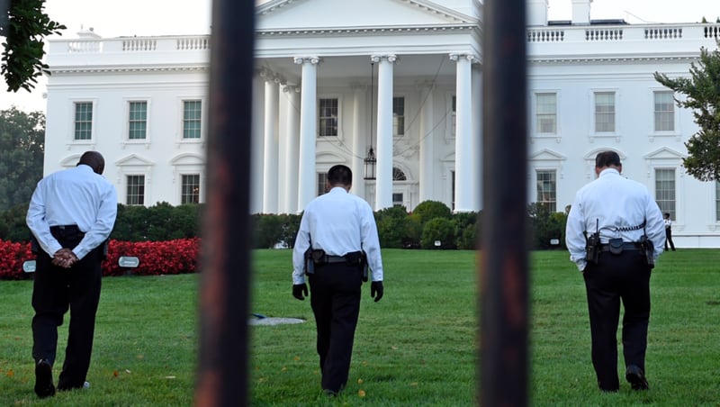 In this file photo, officers are seen checking the grounds of the White House in Washington. President Joe Biden has no public events scheduled today. 