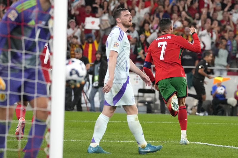 Portugal's Cristiano Ronaldo, right, celebrates after scoring his side's second goal during the UEFA Nations League soccer match between Portugal and Scotland at the Luz stadium in Lisbon, Portugal, Sunday, Sept. 8, 2024. (AP Photo/Armando Franca)