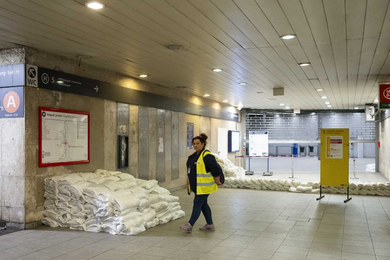 A worker walks by a closed metro station protected by sandbags as the Danube river floods it's banks, central Budapest, Hungary, Thursday, Sept. 19, 2024. (AP Photo/Denes Erdos)