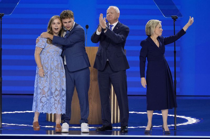 Democratic vice presidential nominee Minnesota Gov. Tim Walz, second from right, poses with his wife Gwen Walz, from right, son Gus Walz and daughter Hope Walz after speaking during the Democratic National Convention Wednesday, Aug. 21, 2024, in Chicago. (AP Photo/J. Scott Applewhite)