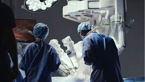 Doctor and surgical assistant working with Intuititive's robotic da Vinci surgical system. (Courtesy Intuitive)