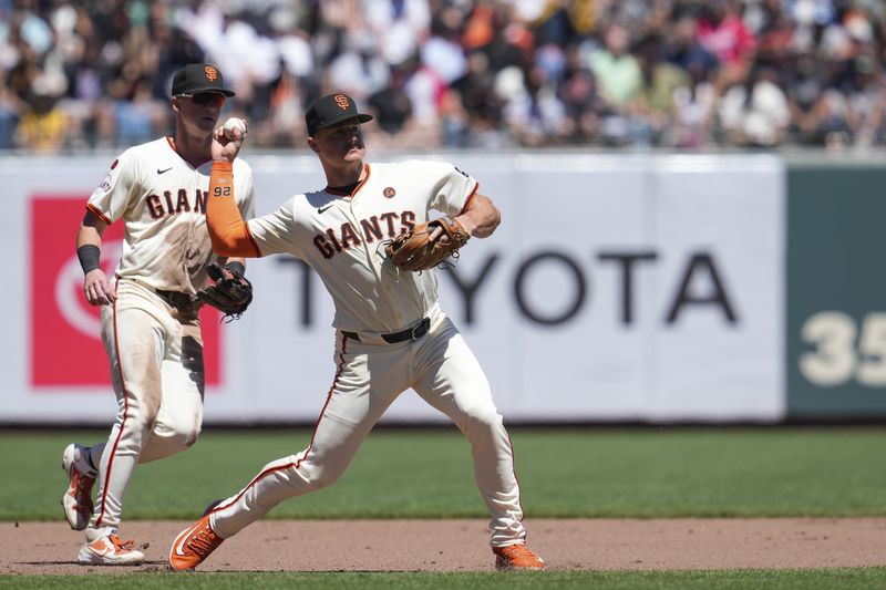 San Francisco Giants third baseman Matt Chapman, right, throws to first for the out on Atlanta Braves' Travis d'Arnaud during the fifth inning of a baseball game Thursday, Aug. 15, 2024, in San Francisco. (AP Photo/Godofredo A. Vásquez)