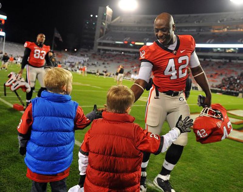 Michael Schoenberg, 6, and twin brother Spencer greet Bulldog defensive end Justin Houston.