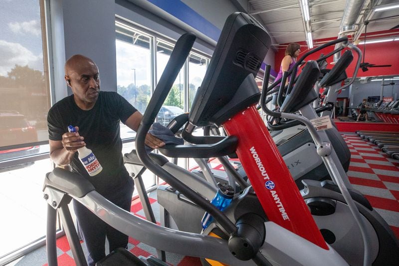 Christopher Ireland, CEO of RideShare, cleans an elliptical after working out at Workout Anytime Gym in Marietta, Ga., on Thursday, Sept. 2, 2021. (Photo/Jenn Finch, The Atlanta Journal-Constitution)