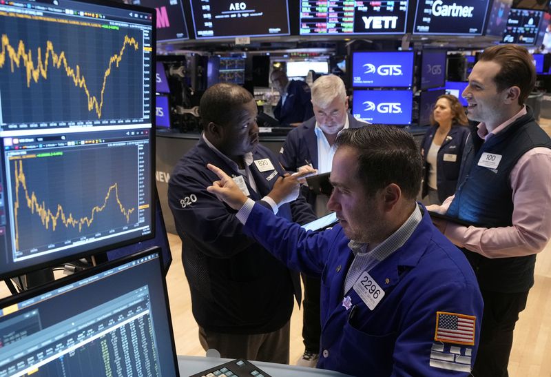 Specialist Genaro Saporito, foreground, works with traders at his post on the floor of the New York Stock Exchange, Wednesday, Sept. 18, 2024. (AP Photo/Richard Drew)