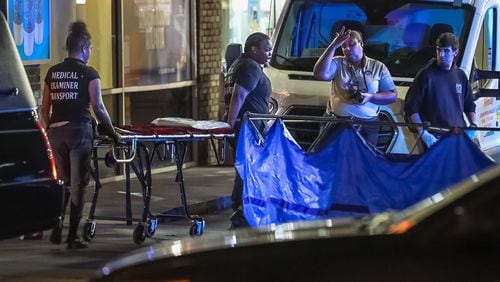 Fulton County Medical Examiner’s Office investigators prepare to transport the victim of a deadly shooting at a Chevron gas station in Buckhead early Thursday morning.