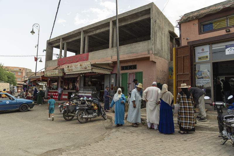 People shop for food at a busy area that was affected by the 2023 earthquake, in the town of Amizmiz, outside Marrakech, Morocco, Wednesday, Sept. 4, 2024. (AP Photo/Mosa'ab Elshamy)