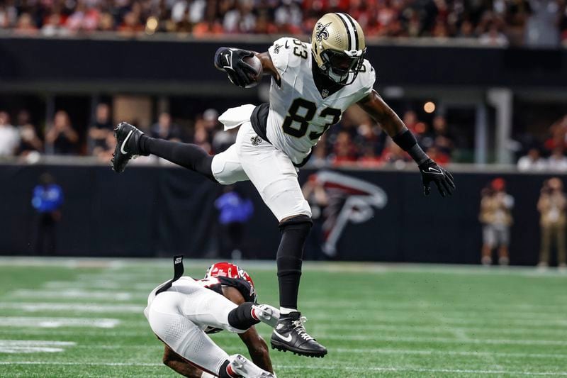 New Orleans Saints tight end Juwan Johnson (83) lewaps over Atlanta Falcons cornerback Dee Alford (20) during the second half of an NFL football game, Sunday, Sept. 29, 2024, in Atlanta. (AP Photo/Butch Dill)