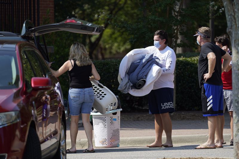 FILE - Students and parents begin to move student's belongings out of Bragaw Hall at N.C. State University in Raleigh, N.C., Thursday, Aug. 27, 2020. (AP Photo/Gerry Broome, File)