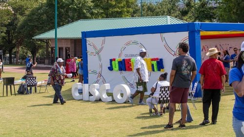 People observe and walk through Cisco’s stand at the Juneteenth Parade and Music Festival in Atlanta on Saturday, June 17, 2023. (Katelyn Myrick/katelyn.myrick@ajc.com)