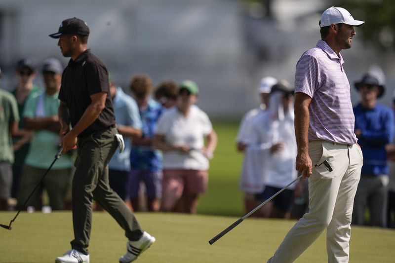 Scottie Scheffler, right and Xander Schauffele walk on the 11th tee during the first round of the Tour Championship golf tournament, Thursday, Aug. 29, 2024, in Atlanta. (AP Photo/Mike Stewart)