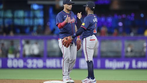 Atlanta Braves shortstop Orlando Arcia, left, and second baseman Ozzi Albies (1) congratulate each other after the Braves beat the Miami Marlins 5-4, during a baseball game, Sunday, Sept. 22, 2024, in Miami. (AP Photo/Wilfredo Lee)