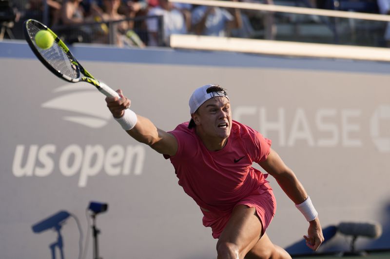 Brandon Nakashima, of the United States, returns a shot to Holger Rune, of Denmark, during a first round match of the U.S. Open tennis championships, Monday, Aug. 26, 2024, in New York. (AP Photo/Matt Rourke)