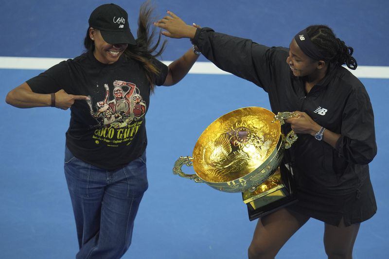 Coco Gauff of the United States, right, celebrates with her mother Candi Gauff after defeating Karolina Muchova of Czech Republic in the women's singles final match at the China Open tennis tournament at the National Tennis Center in Beijing, Sunday, Oct. 6, 2024. (AP Photo/Ng Han Guan)